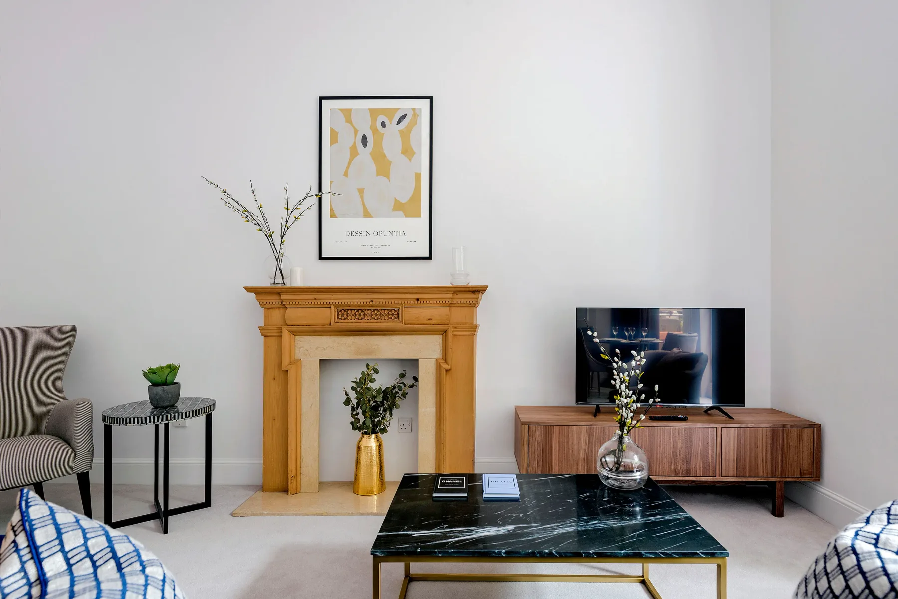 A living room with a wooden fireplace, television, and central coffee table.