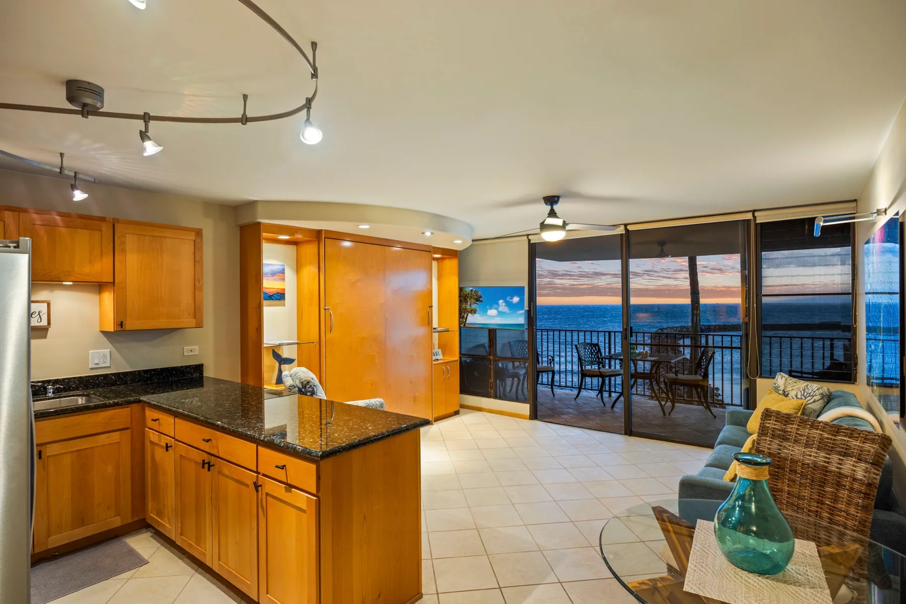 An open kitchen and living area faces glass doors overlooking the water.