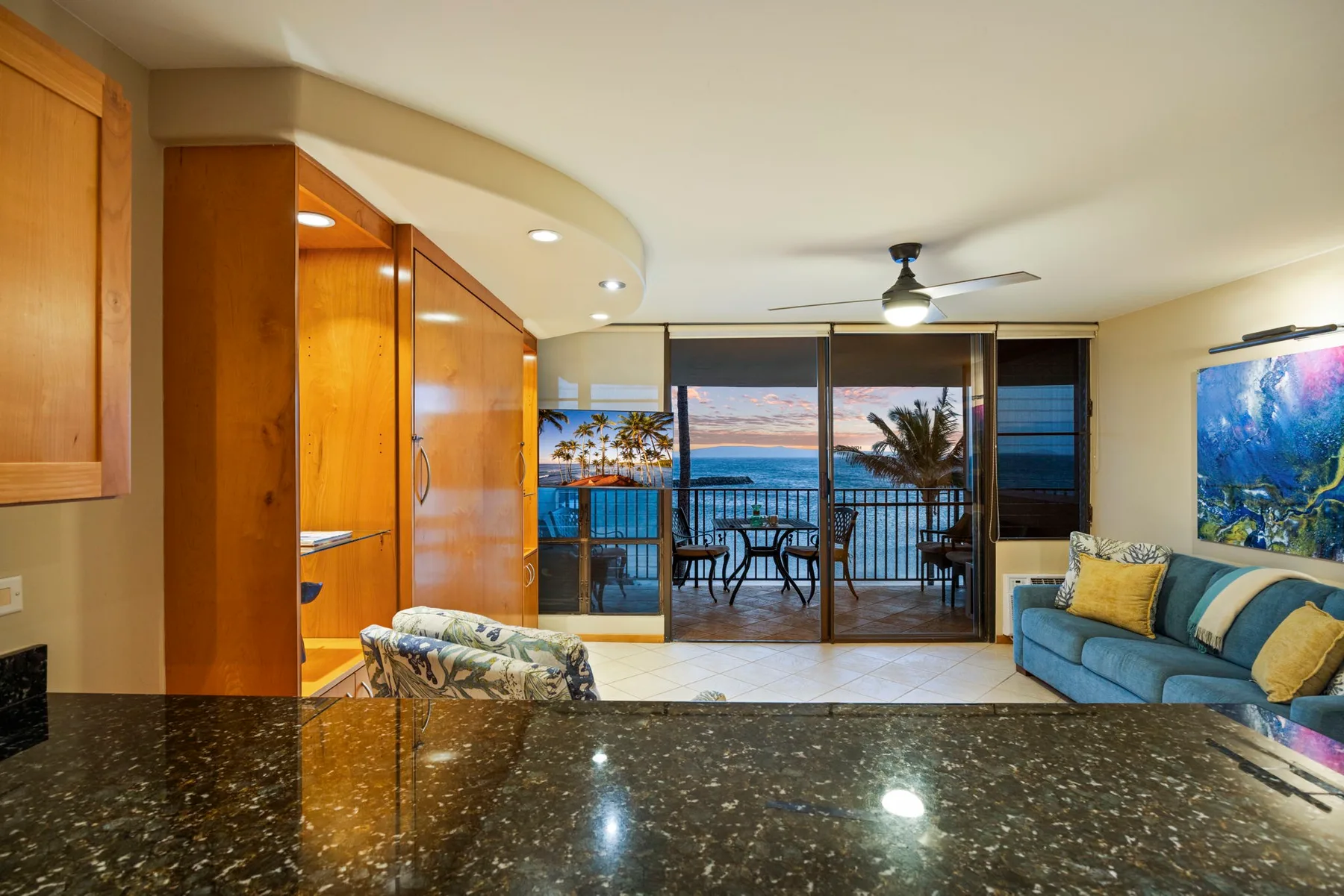 A living area opens onto a balcony with a table and ocean views.