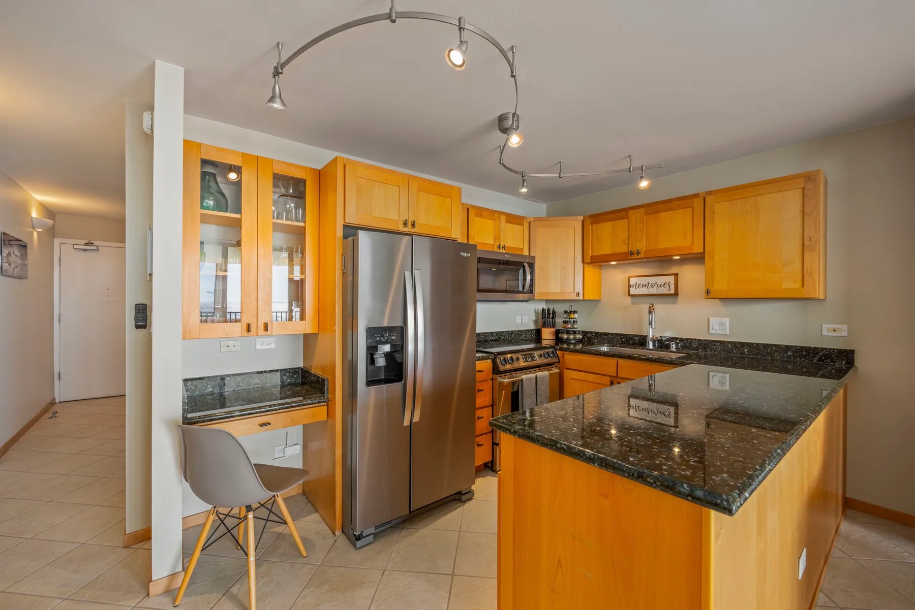A kitchen with wooden cabinets, stainless steel appliances, and a central island.