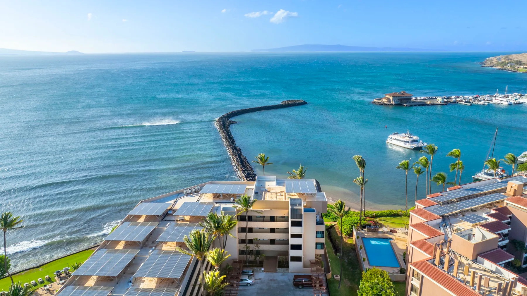 A coastal resort complex overlooks a sheltered bay and open sea.
