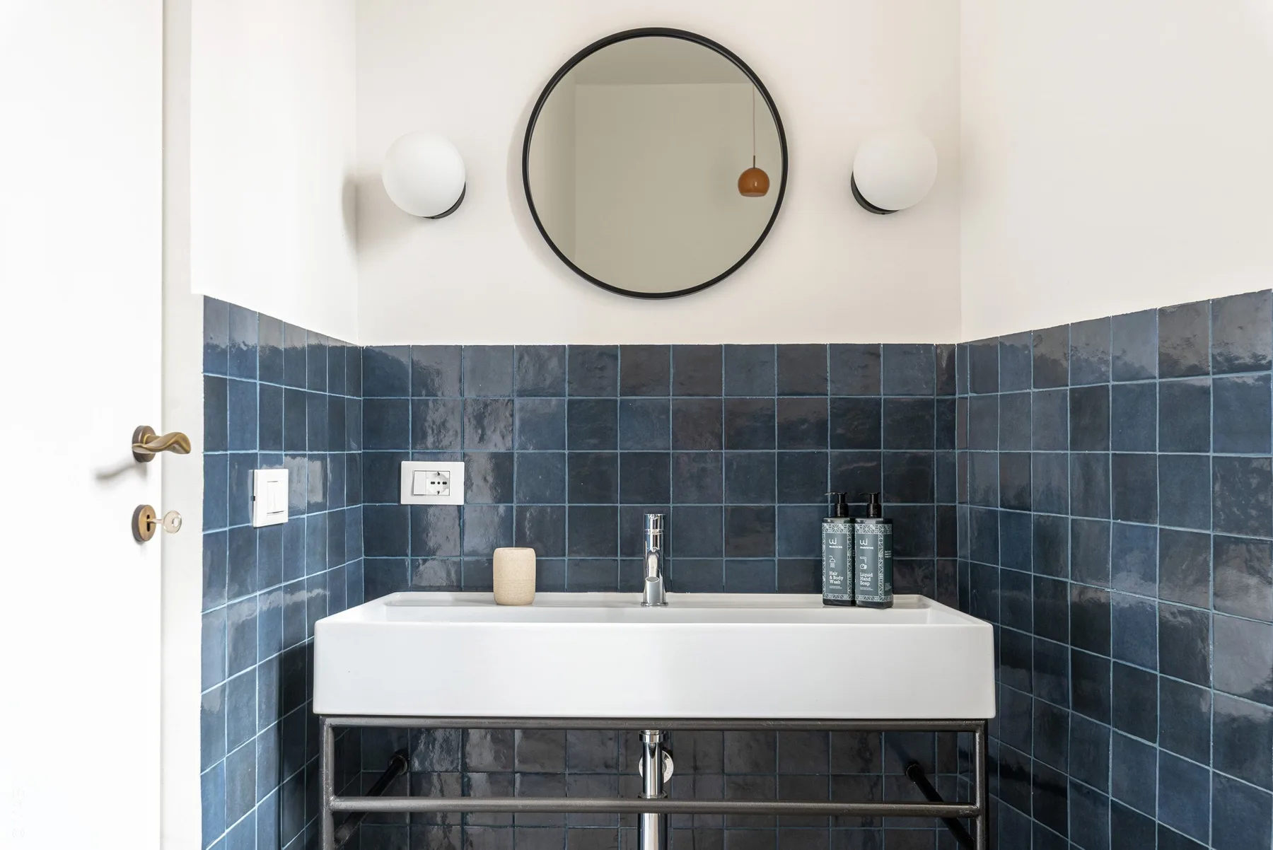 A bathroom vanity with a round mirror above the sink.
