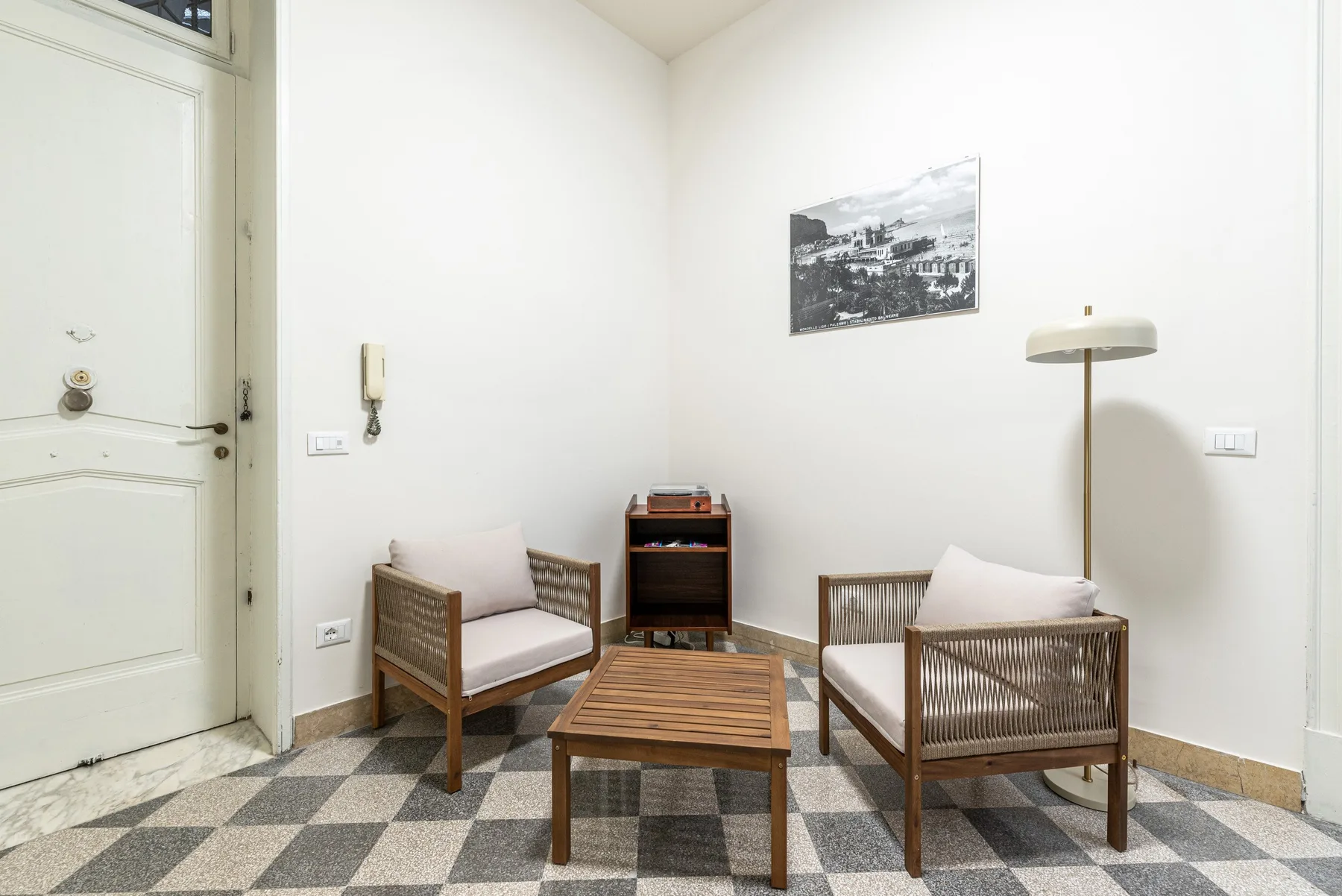 A bright living room with two wooden seats and a low coffee table.