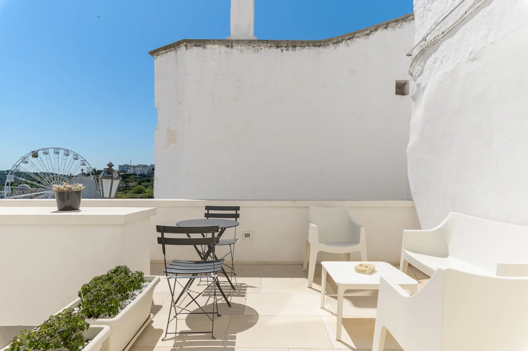 Una terraza soleada en la azotea con asientos al aire libre y una mesa baja.