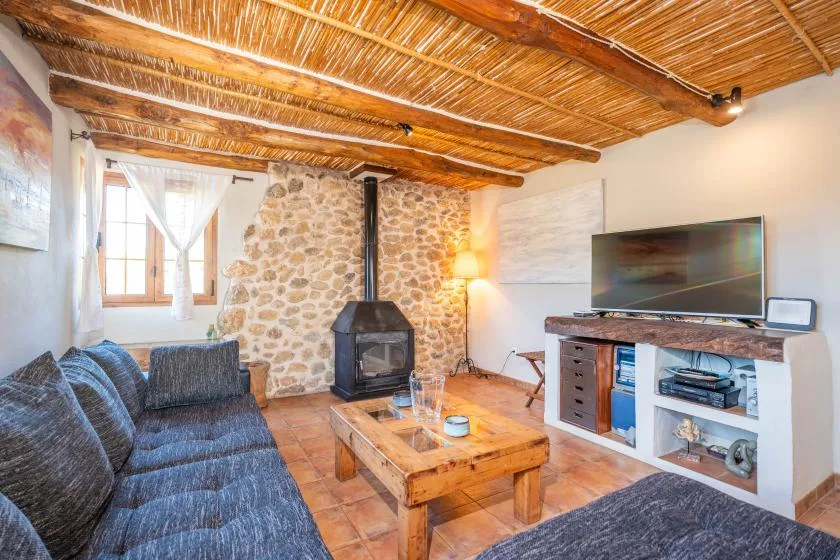 Una sala de estar con asientos, una mesa de centro de madera y un televisor.