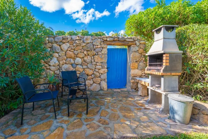 Un patio de piedra con asientos al aire libre y una barbacoa.