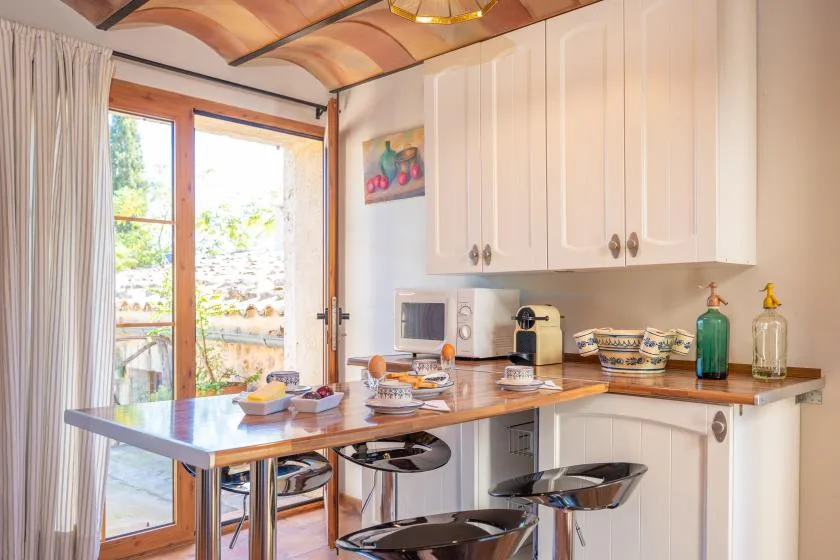 Una cocina luminosa con una encimera y una puerta de vidrio que da a un balcón.