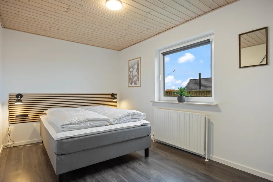 Un dormitorio con una cama junto a una ventana y un radiador.