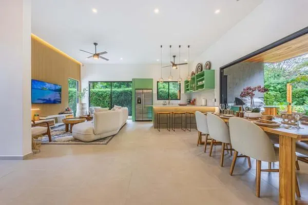 Sala, comedor y cocina en un espacio abierto con vistas al jardín.
