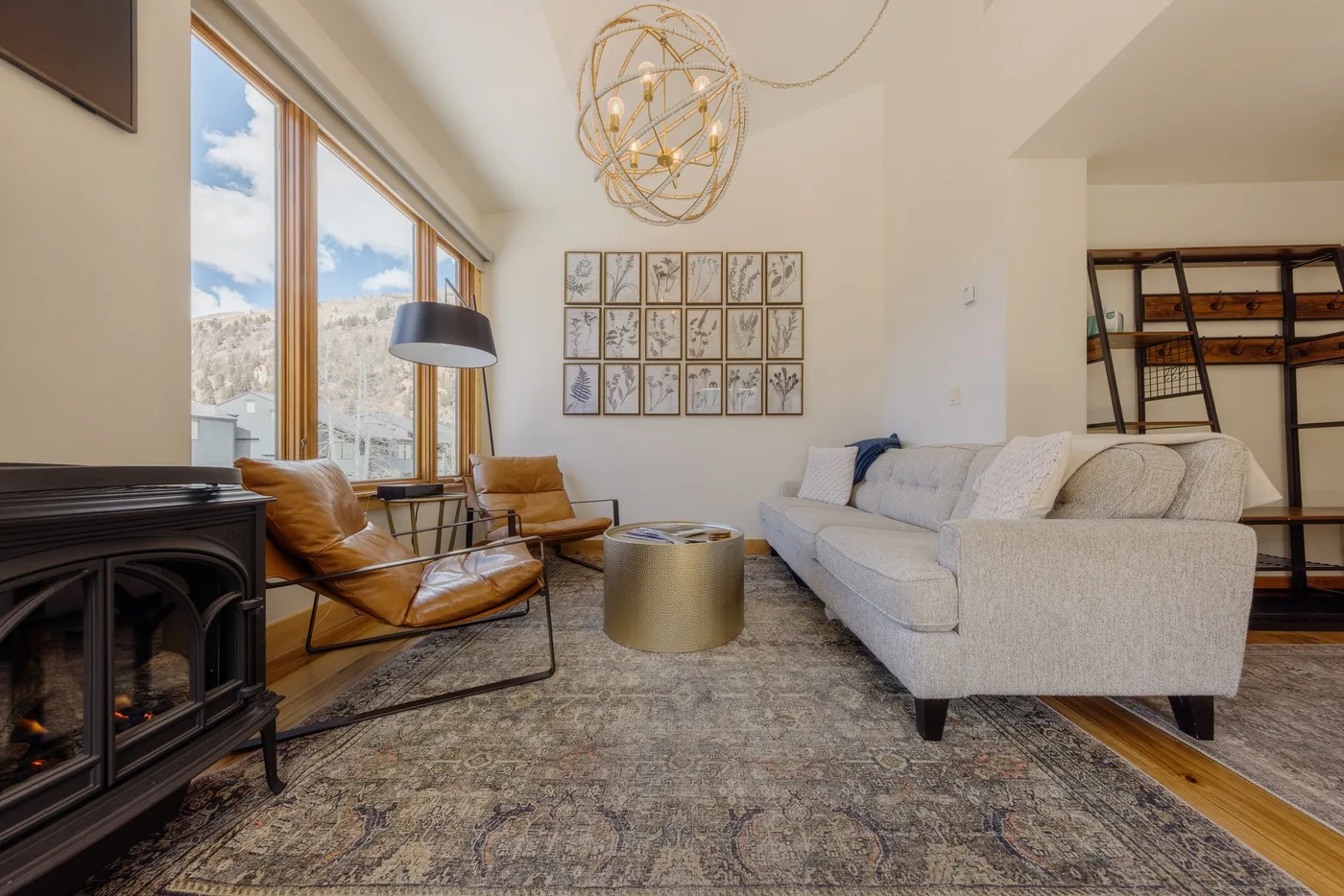 Una sala luminosa con asientos alrededor de una mesa de centro junto a grandes ventanas.