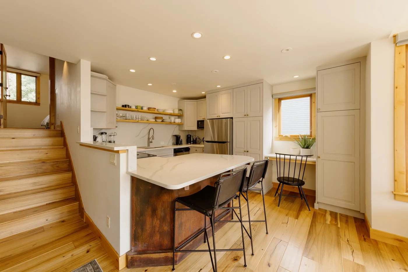 Una cocina luminosa con una isla central y asientos.