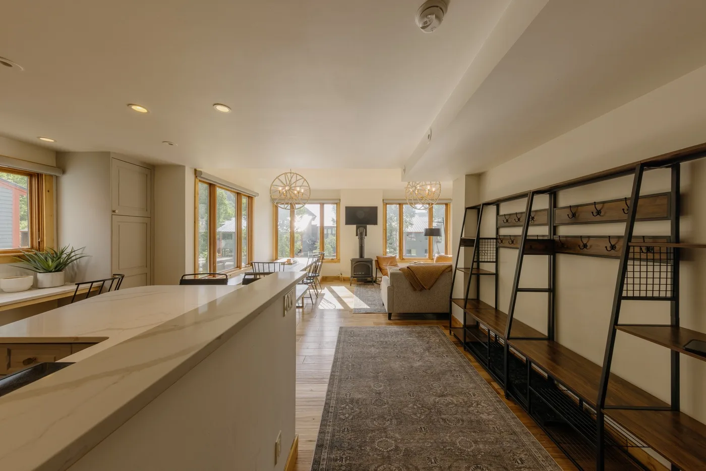 Una luminosa cocina abierta al salón, con una isla larga y estanterías.