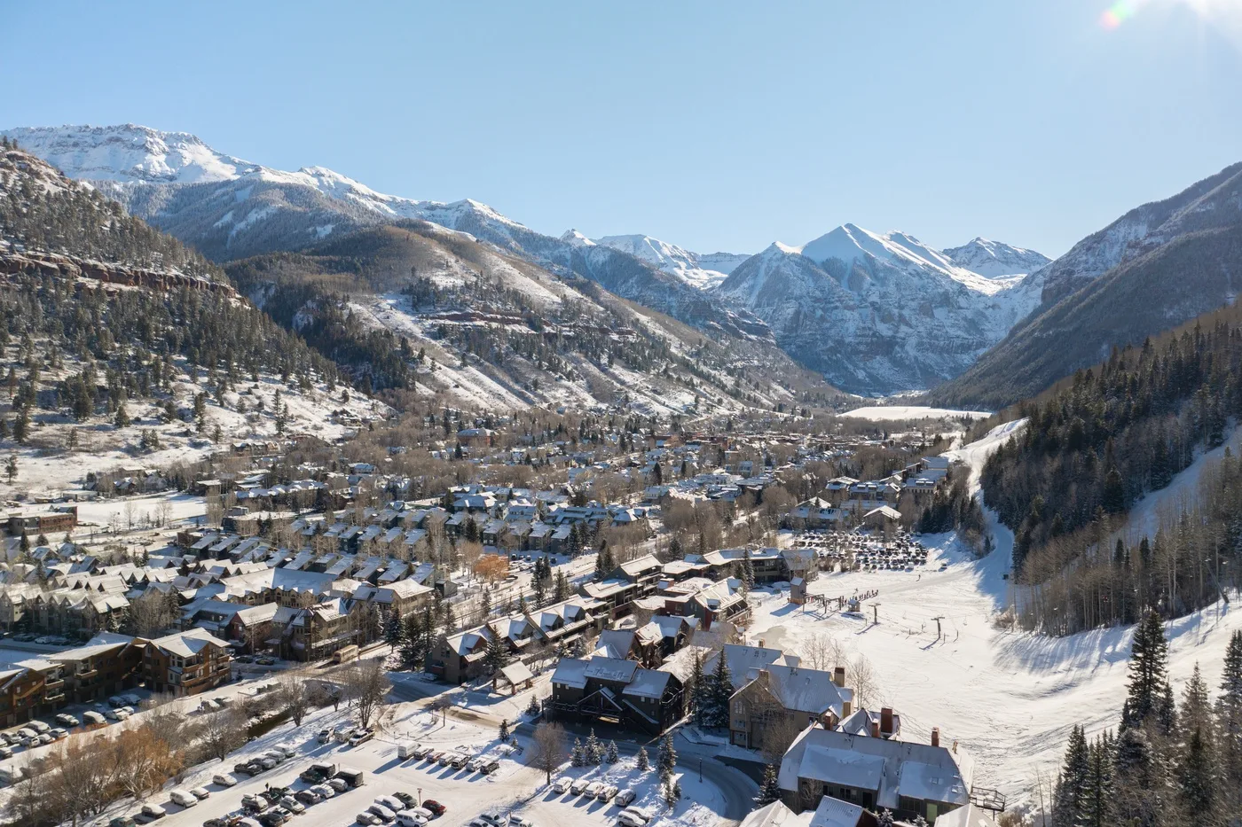 Un pueblo cubierto de nieve se encuentra en un valle entre montañas escarpadas.