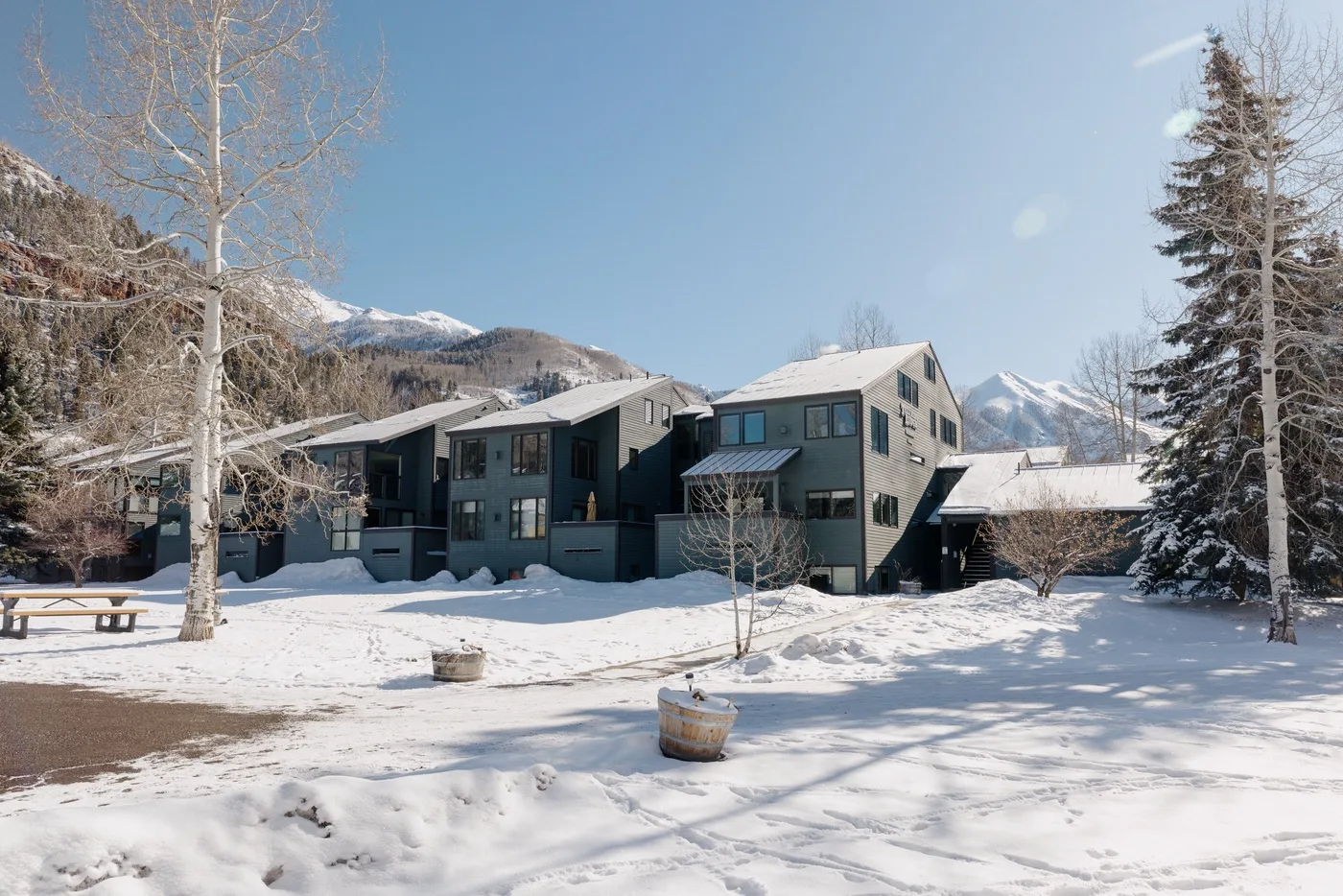 Un edificio de varios niveles se alza en un paisaje montañoso nevado bajo un cielo despejado.
