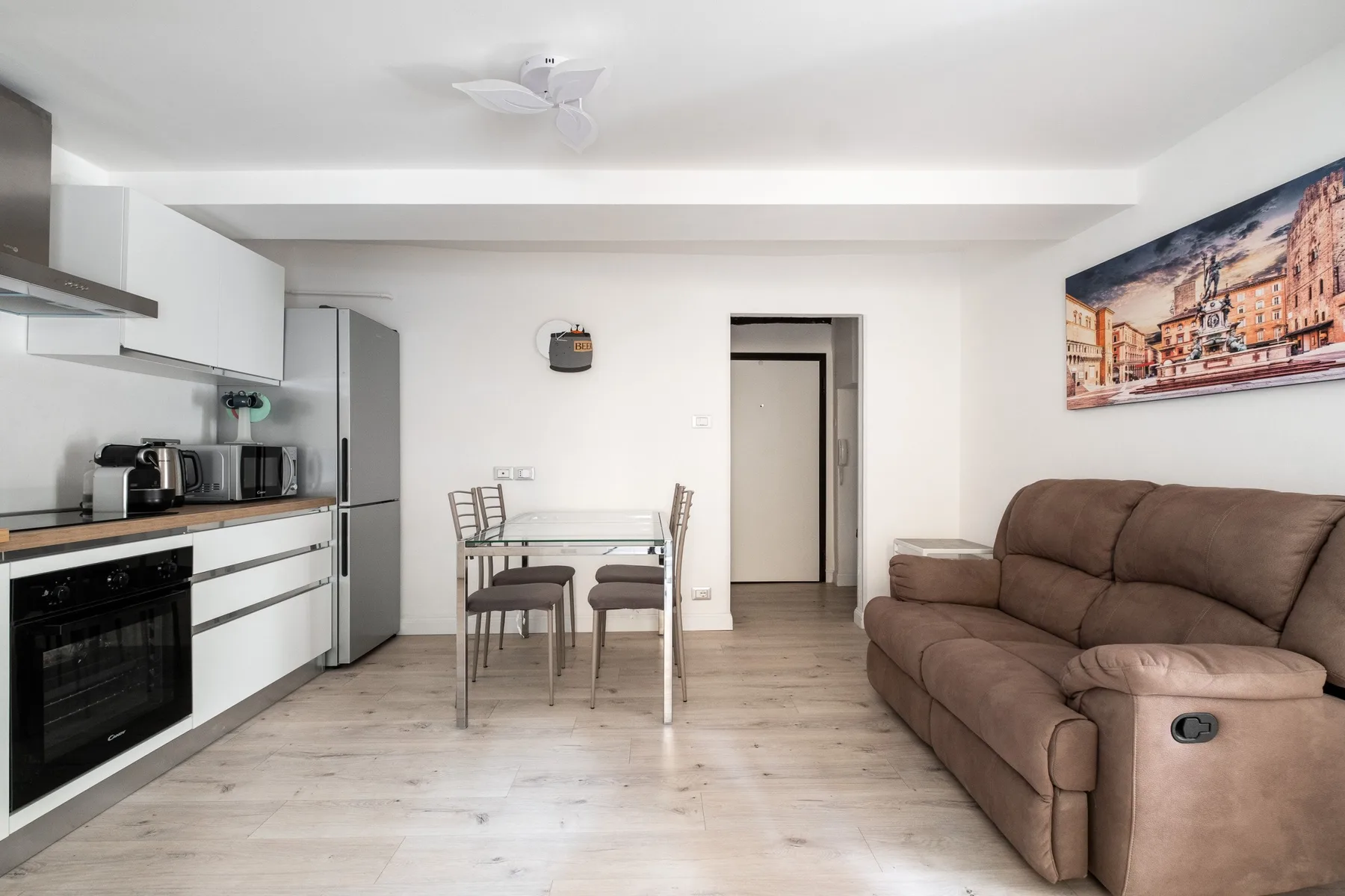 Sala de estar y cocina de concepto abierto con mesa de comedor y asientos.