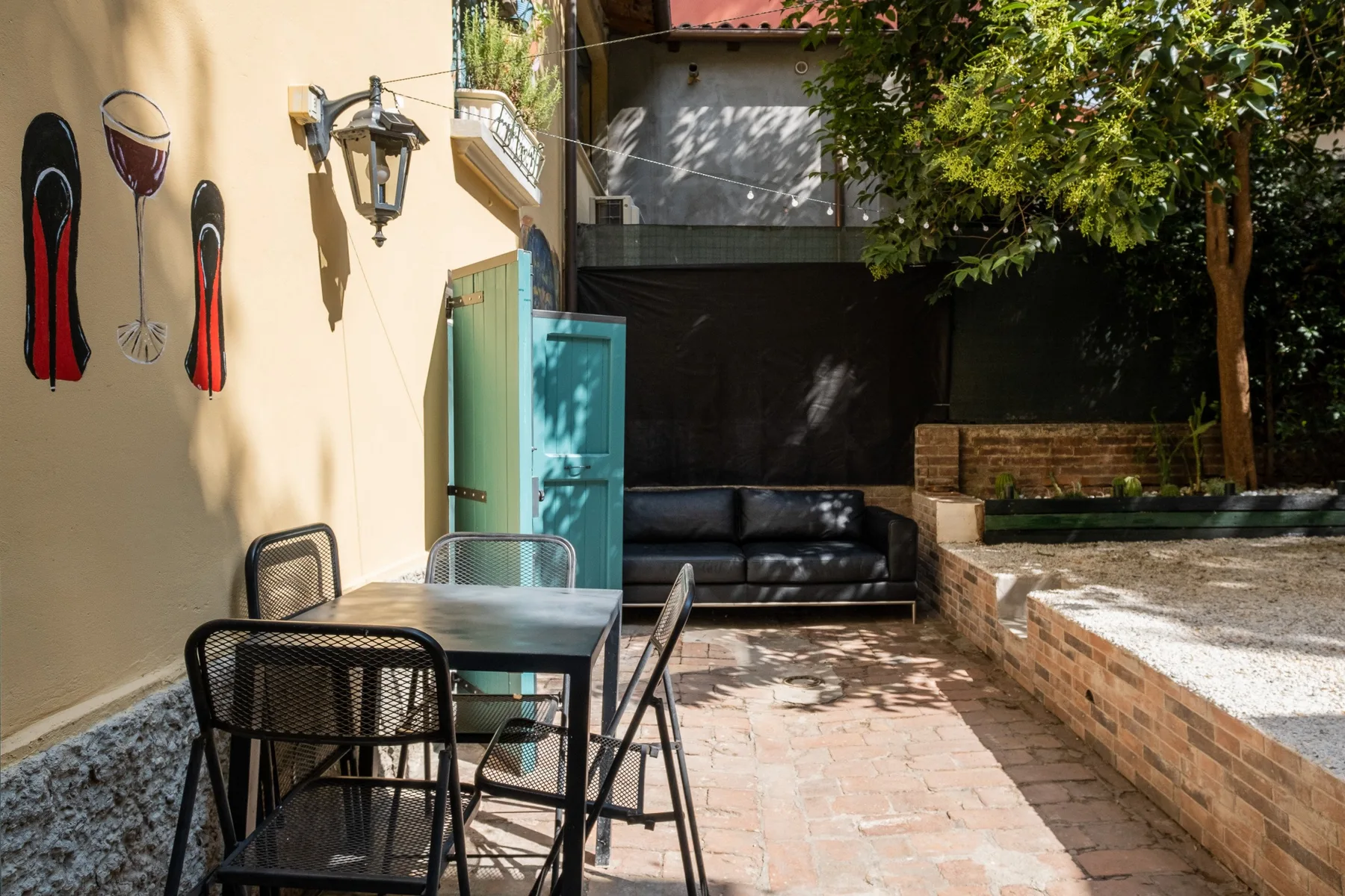 Una zona de estar al aire libre con una mesa y un banco junto a la pared.