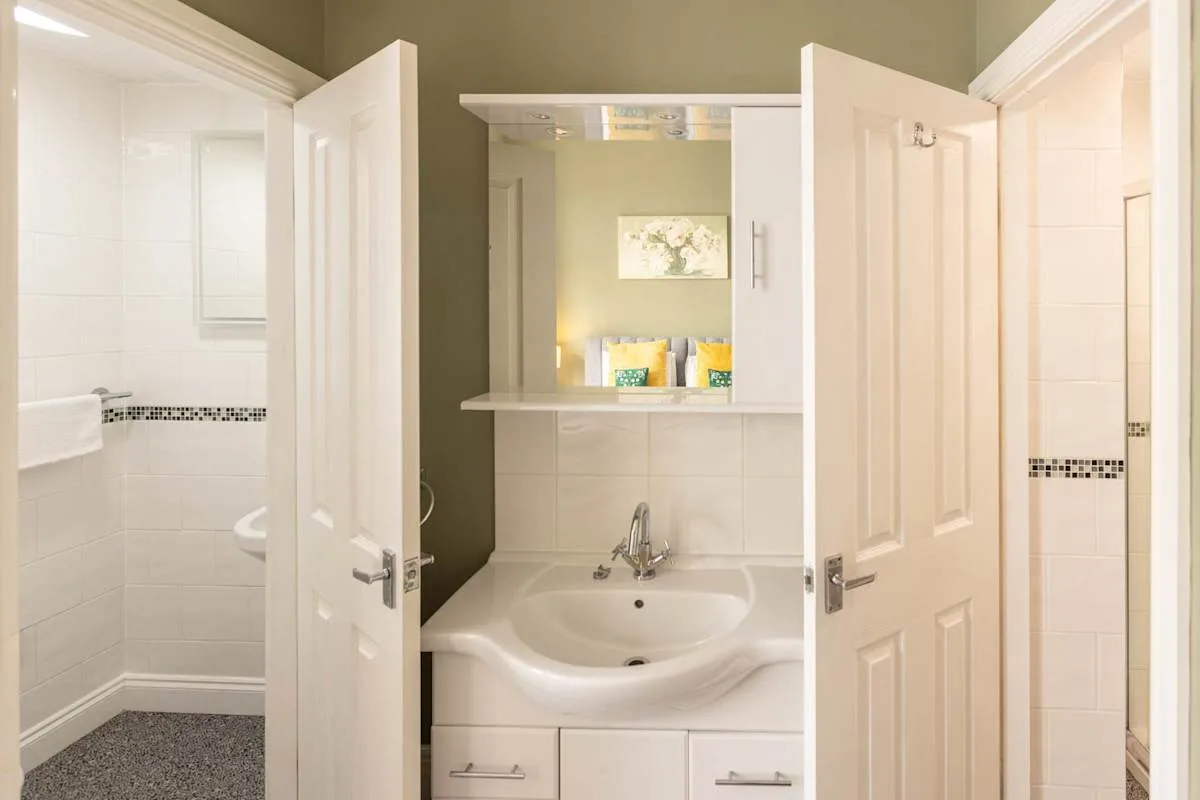 A bathroom vanity with a sink sits beneath a mirrored cabinet.