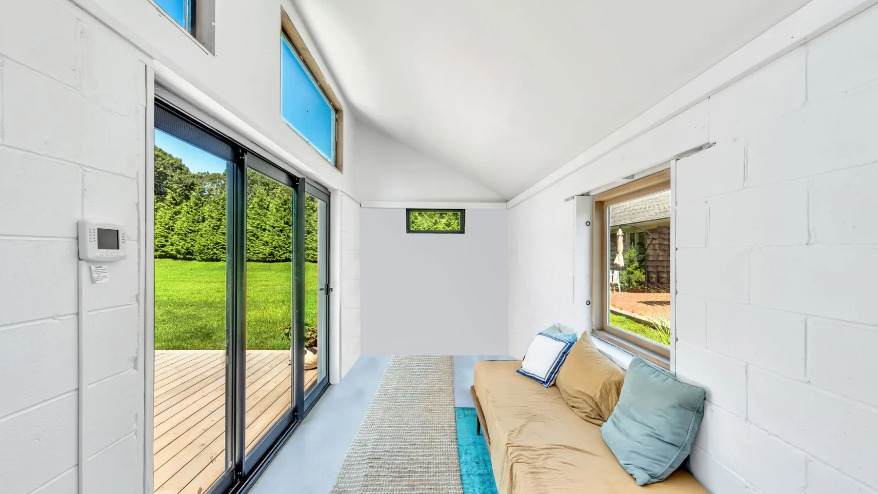 A bright living room with sliding glass doors opening onto a wooden deck.