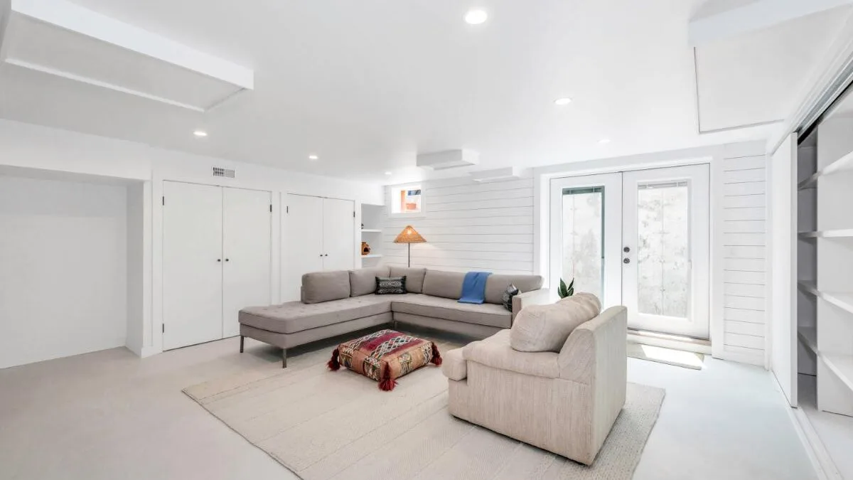 A bright living room with seating arranged around a rug and low table.