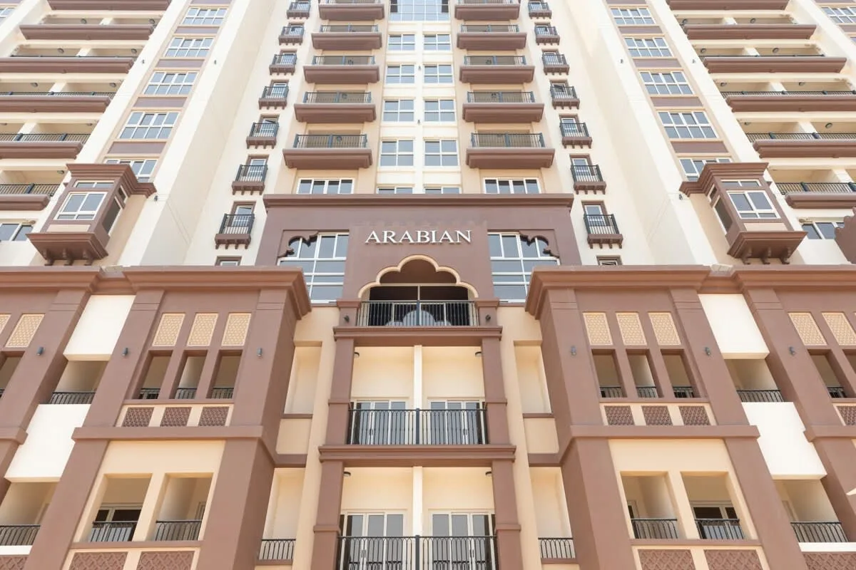 Un edificio alto de apartamentos con filas de balcones y ventanas.