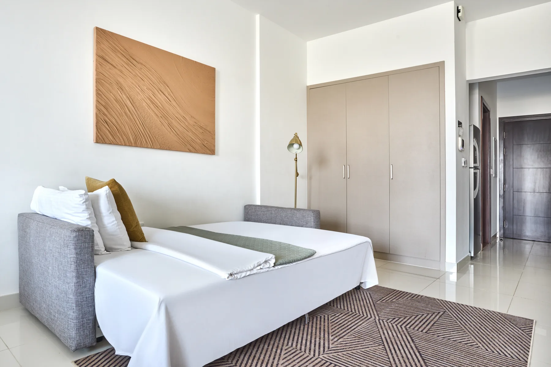 Un dormitorio luminoso con una cama bien tendida y un armario empotrado.