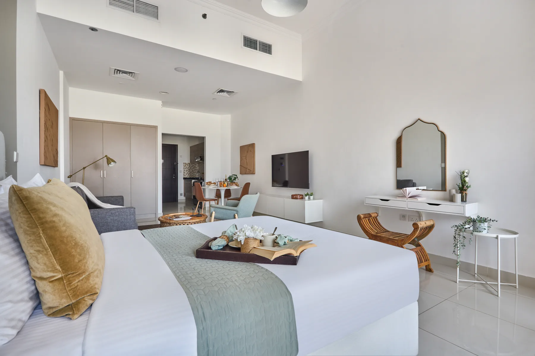 A bright bedroom with a large bed and a seating area.