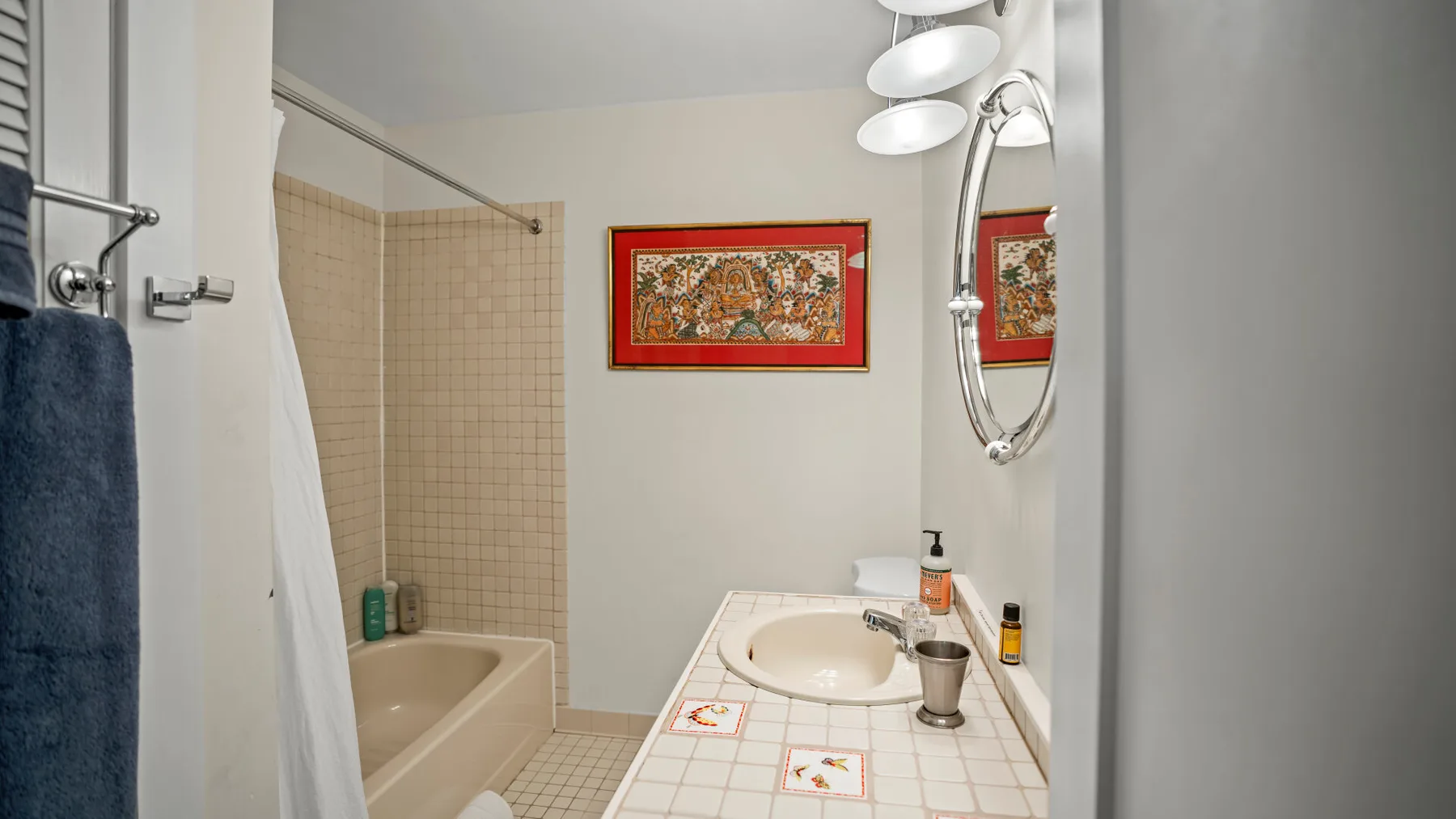 Un baño con bañera, zona de ducha alicatada y lavabo.