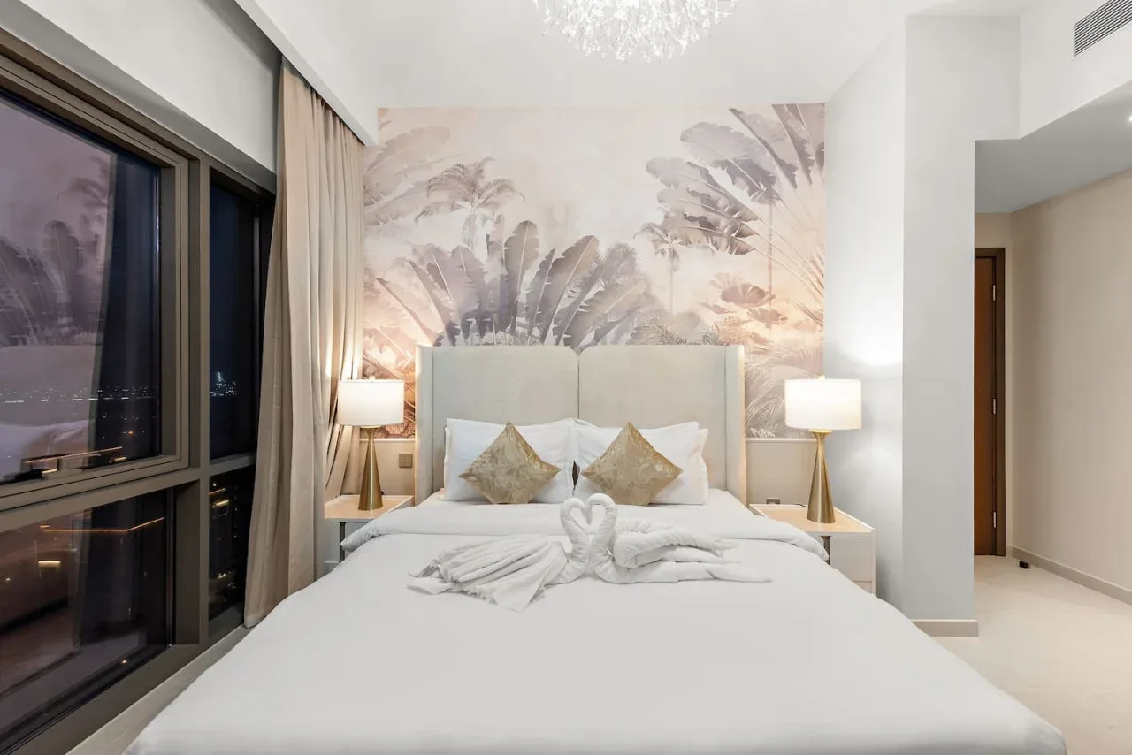Un dormitorio con una cama bien tendida y un gran mural botánico en la pared.
