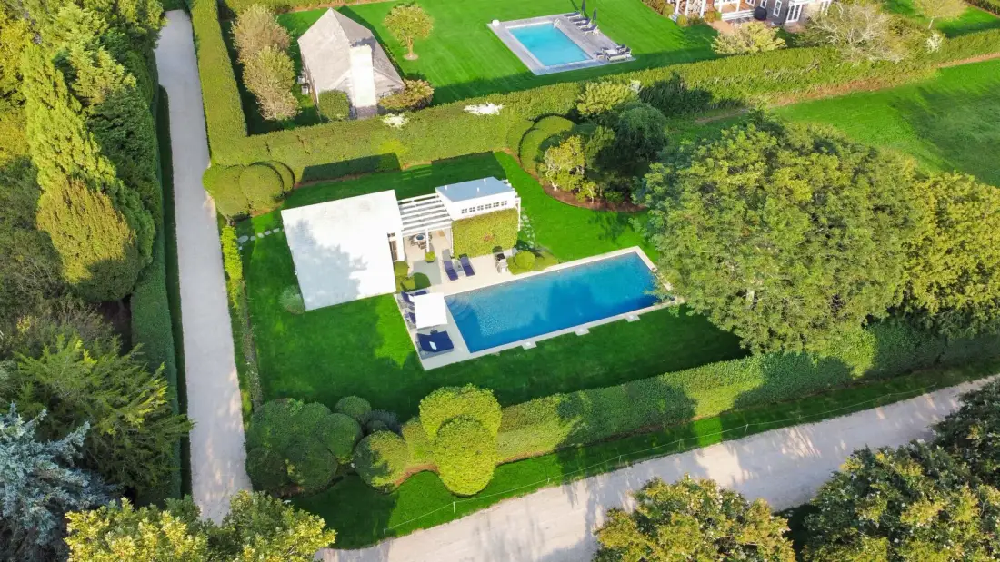 Vista aérea de una propiedad ajardinada con una casa y una piscina.