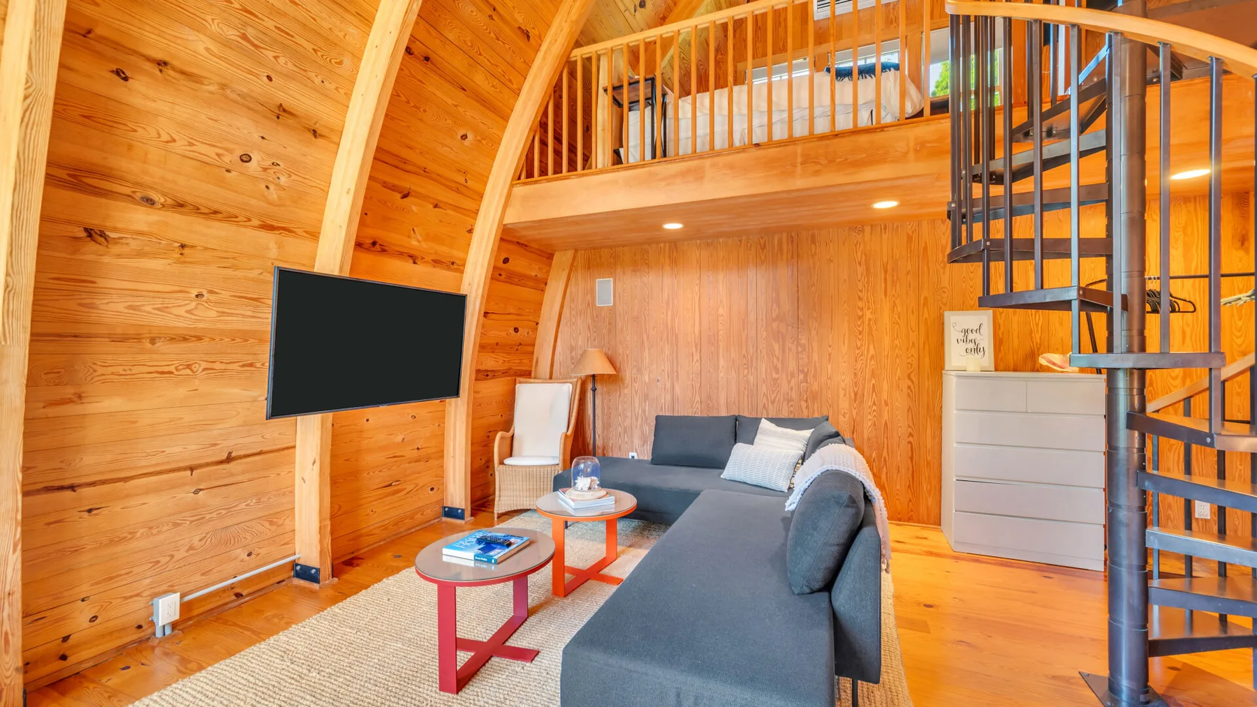 Una sala de estar revestida de madera con una zona de asientos y una escalera de caracol.