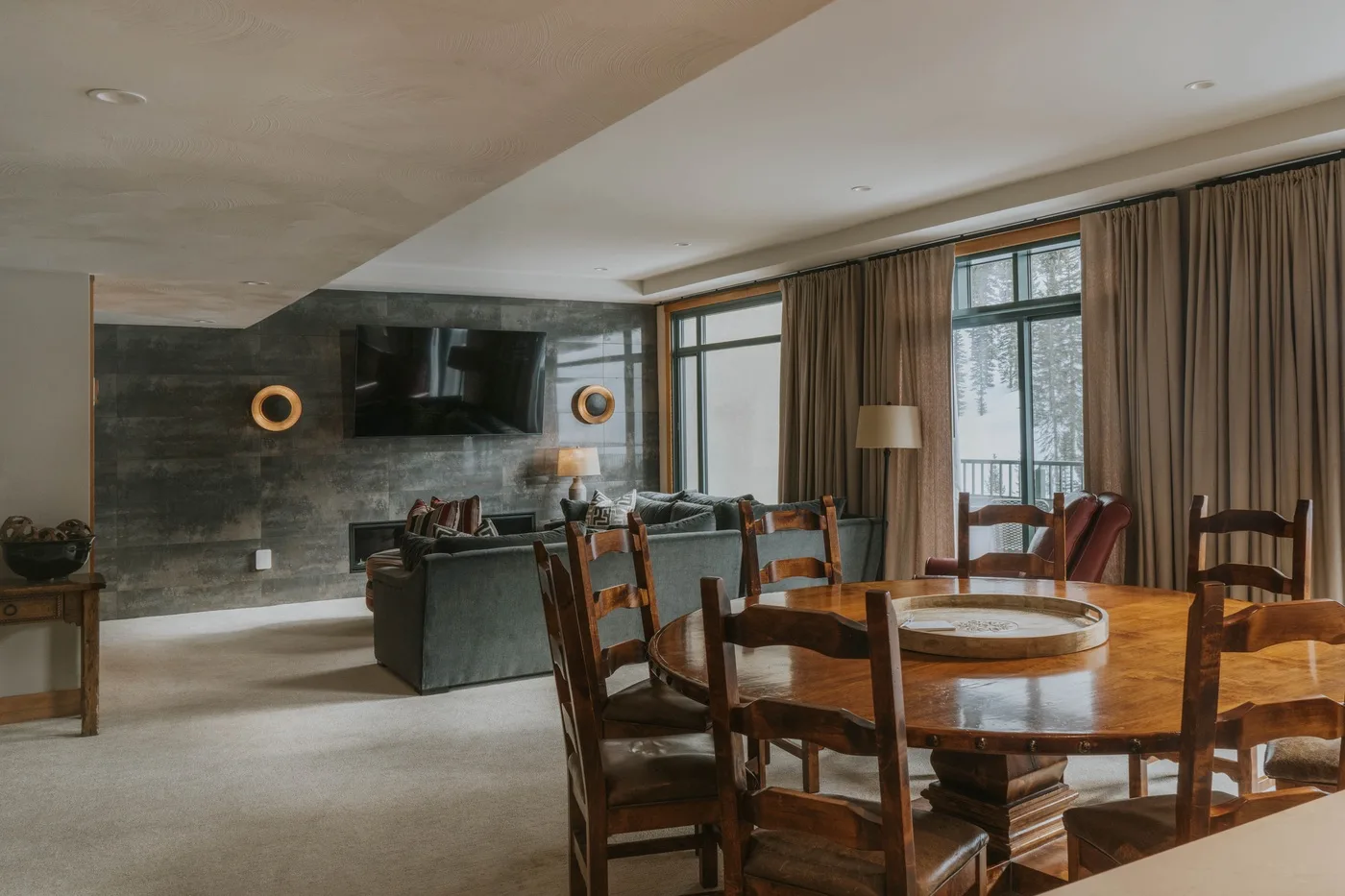 A dining area with a wooden table and chairs beside a living room.