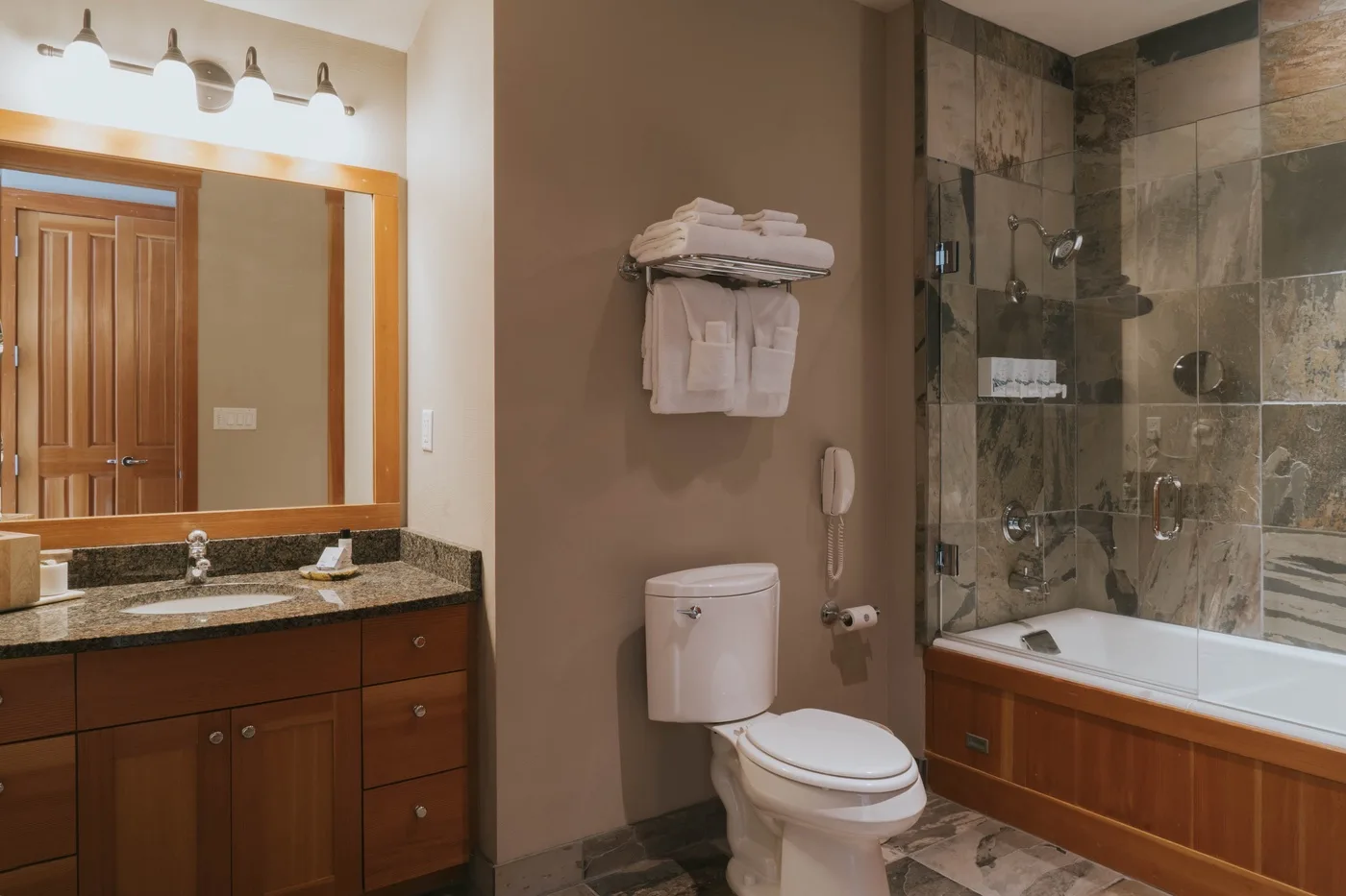 A bathroom with a vanity, toilet, and glass-enclosed shower.