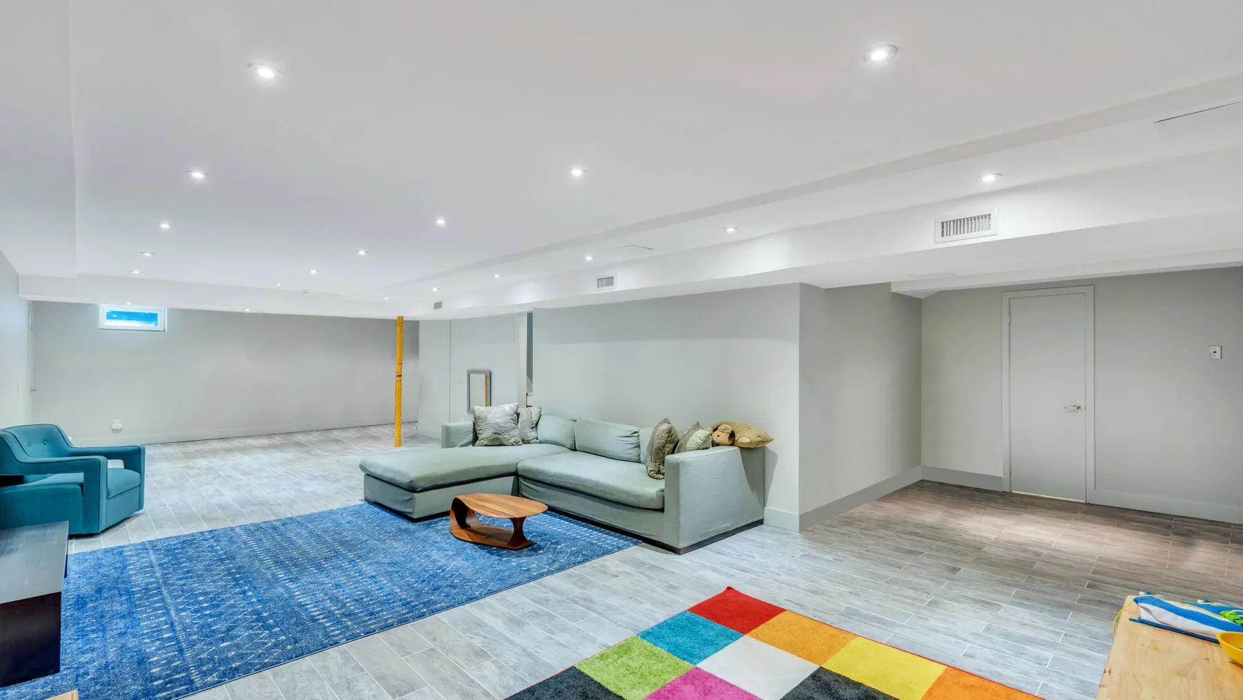 Una sala luminosa con asientos alrededor de una mesa baja sobre una alfombra azul.