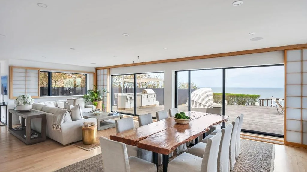 Una luminosa sala y comedor de concepto abierto da a una terraza con vistas al mar.