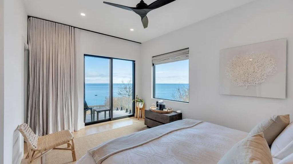 Un dormitorio luminoso se abre a un balcón con vistas al mar.
