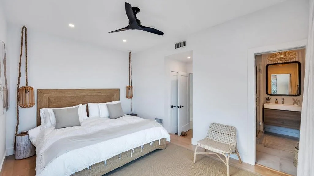 Un dormitorio luminoso con una cama grande y una puerta que da al baño.