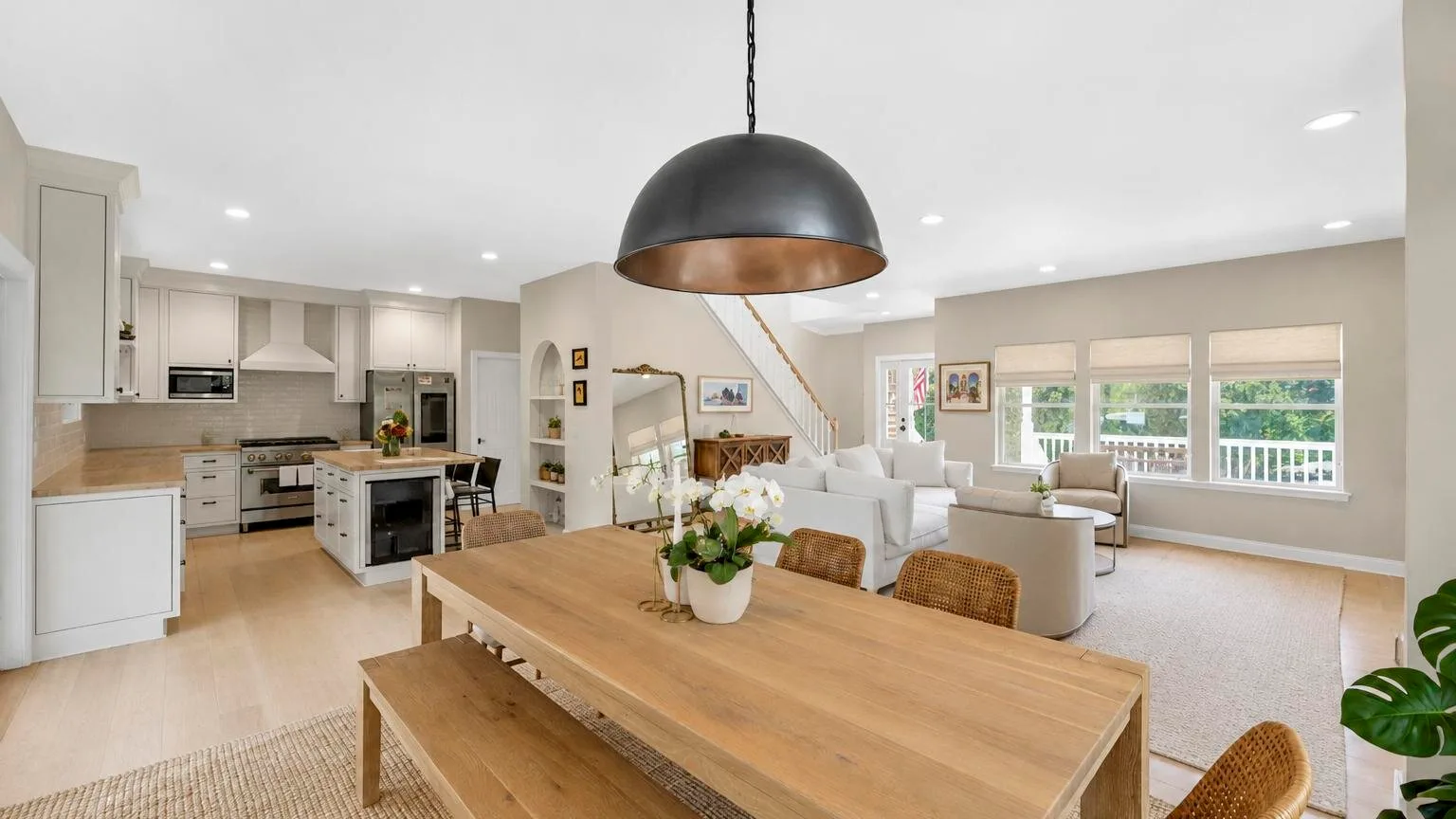 Una sala-comedor de concepto abierto con cocina y ventanas grandes.