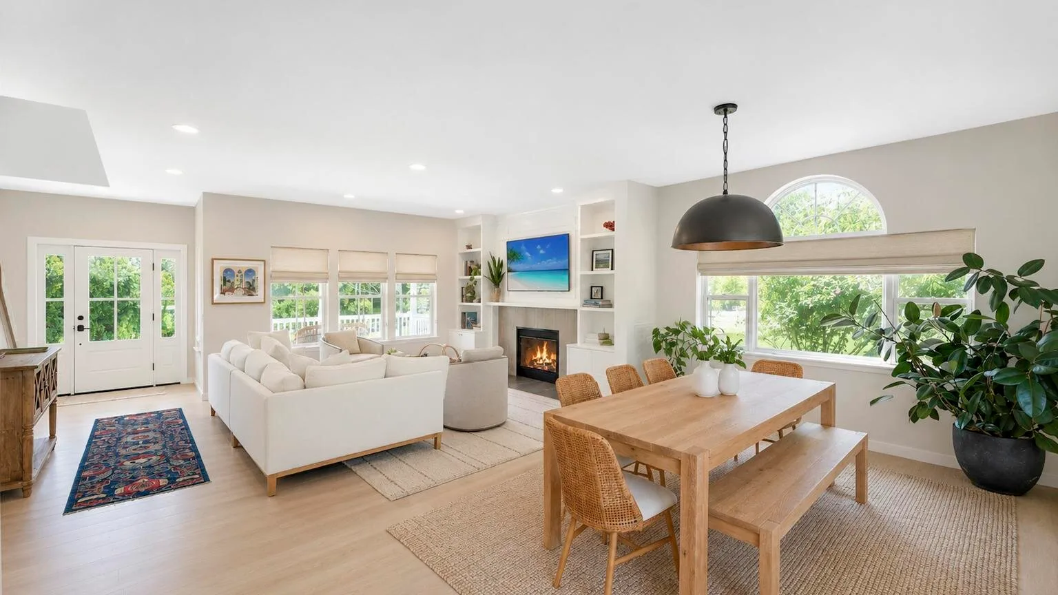A bright open-plan living and dining area with a large wooden table.