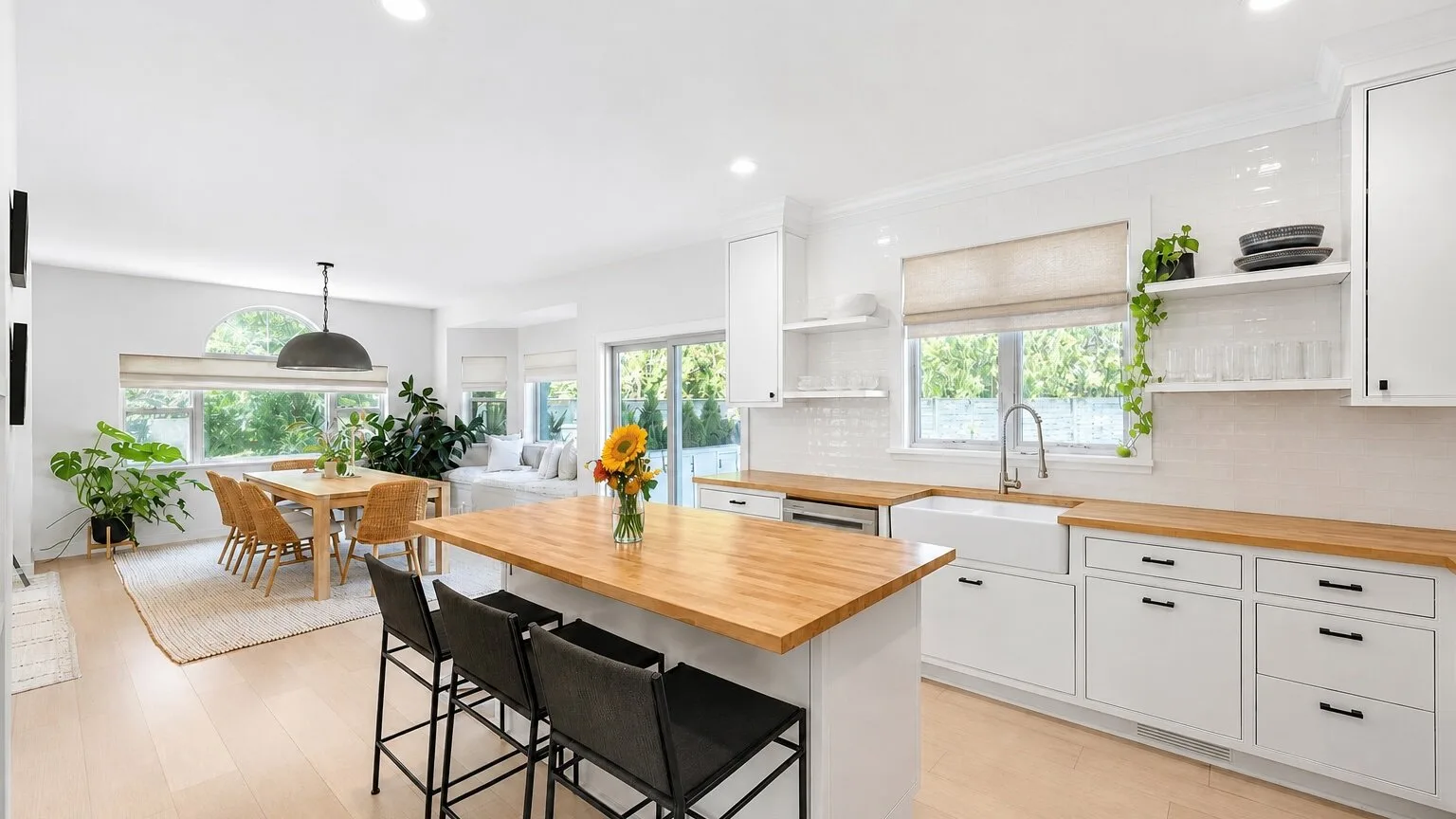 Una luminosa cocina abierta con una gran isla de madera y una mesa de comedor.