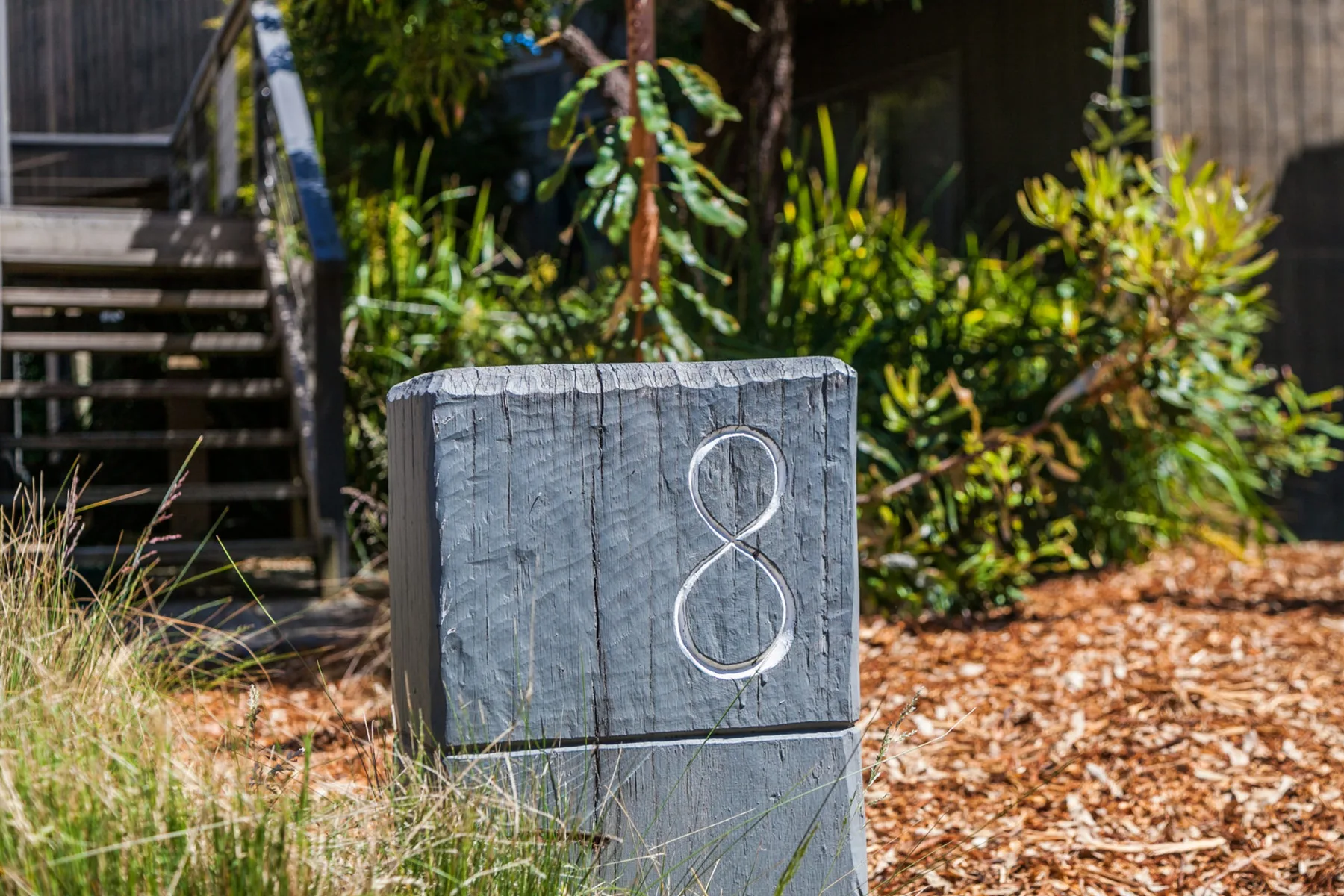 A garden path is marked by a wooden post with the number eight.