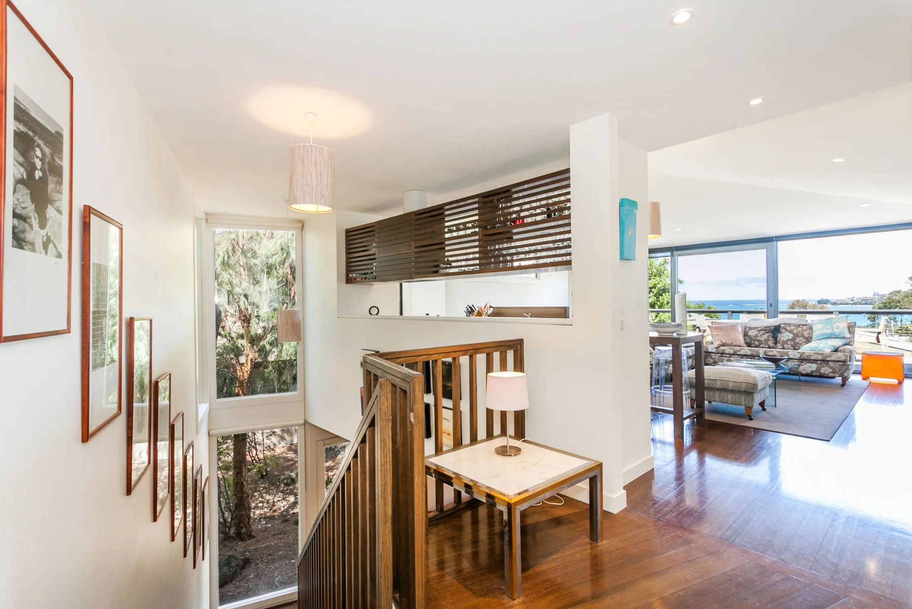 A bright interior hallway opens onto a living area with views of the water.