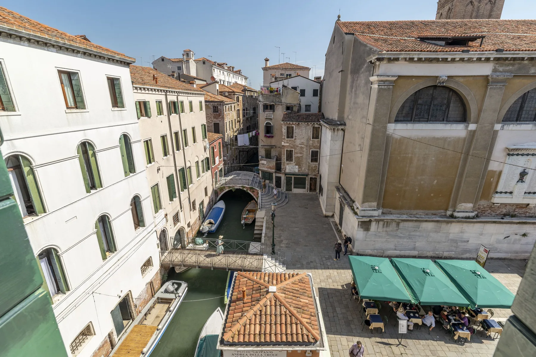 A canal-side square is lined with historic buildings and outdoor café seating.