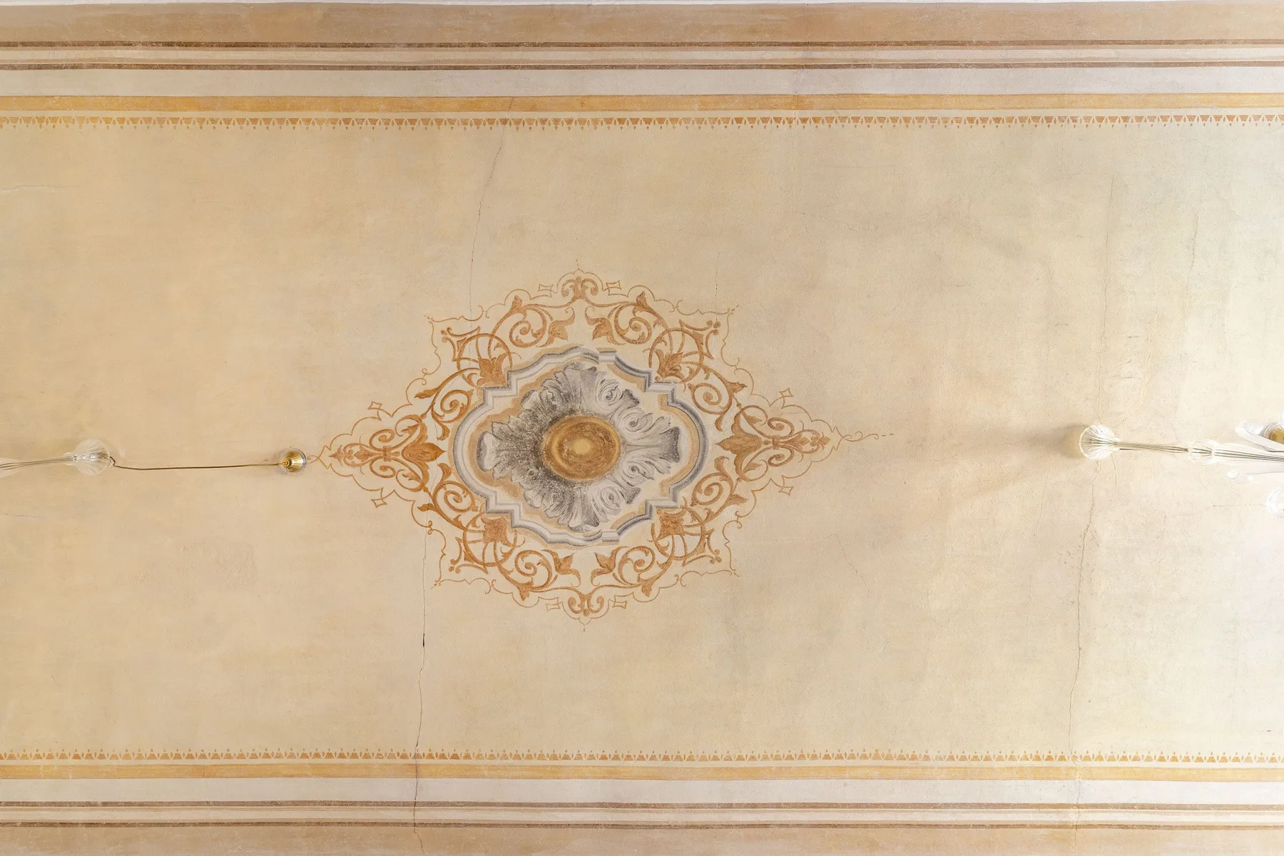 A decorative ceiling with an ornate central medallion and warm-toned detailing.