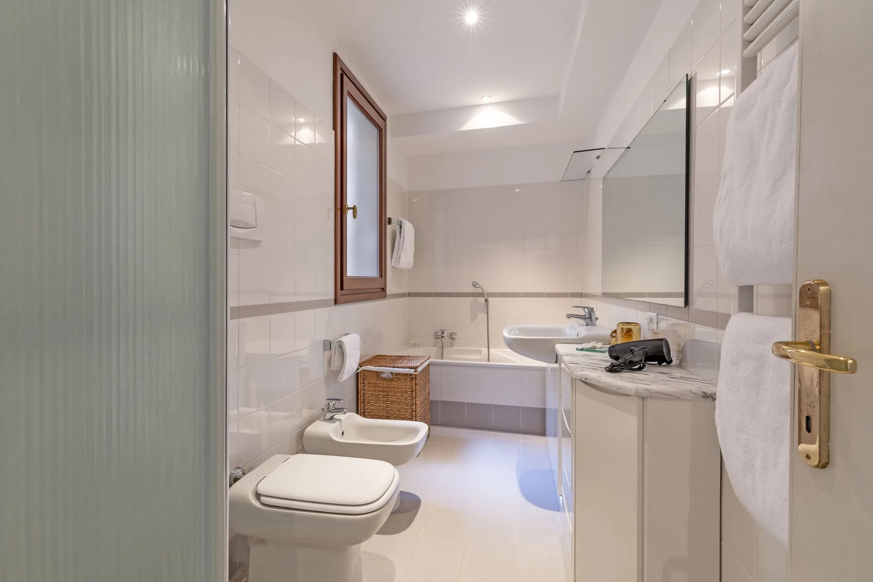 A bright bathroom with a bathtub, sink, and toilet.