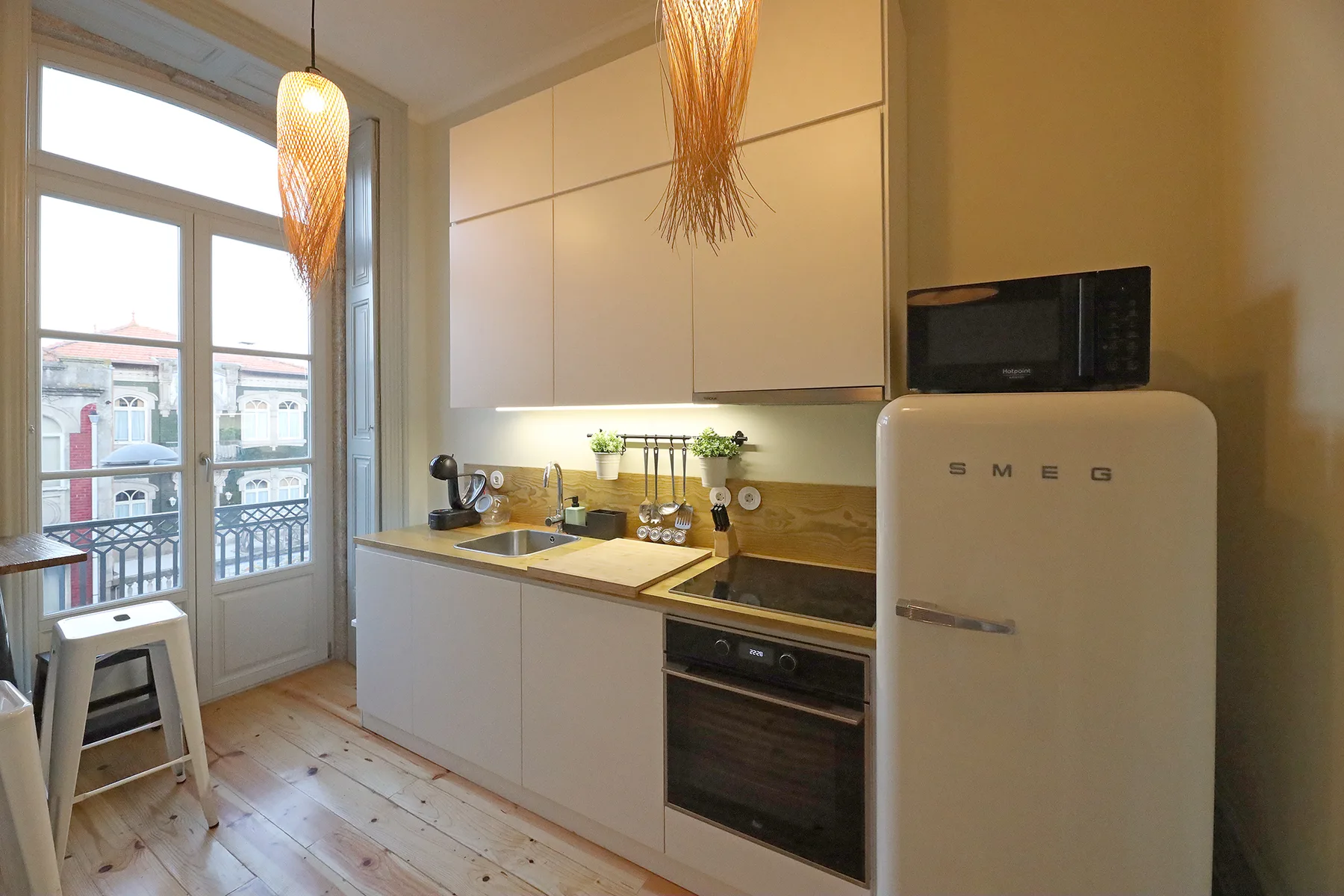 A bright kitchen with white cabinets, a countertop, and a refrigerator.