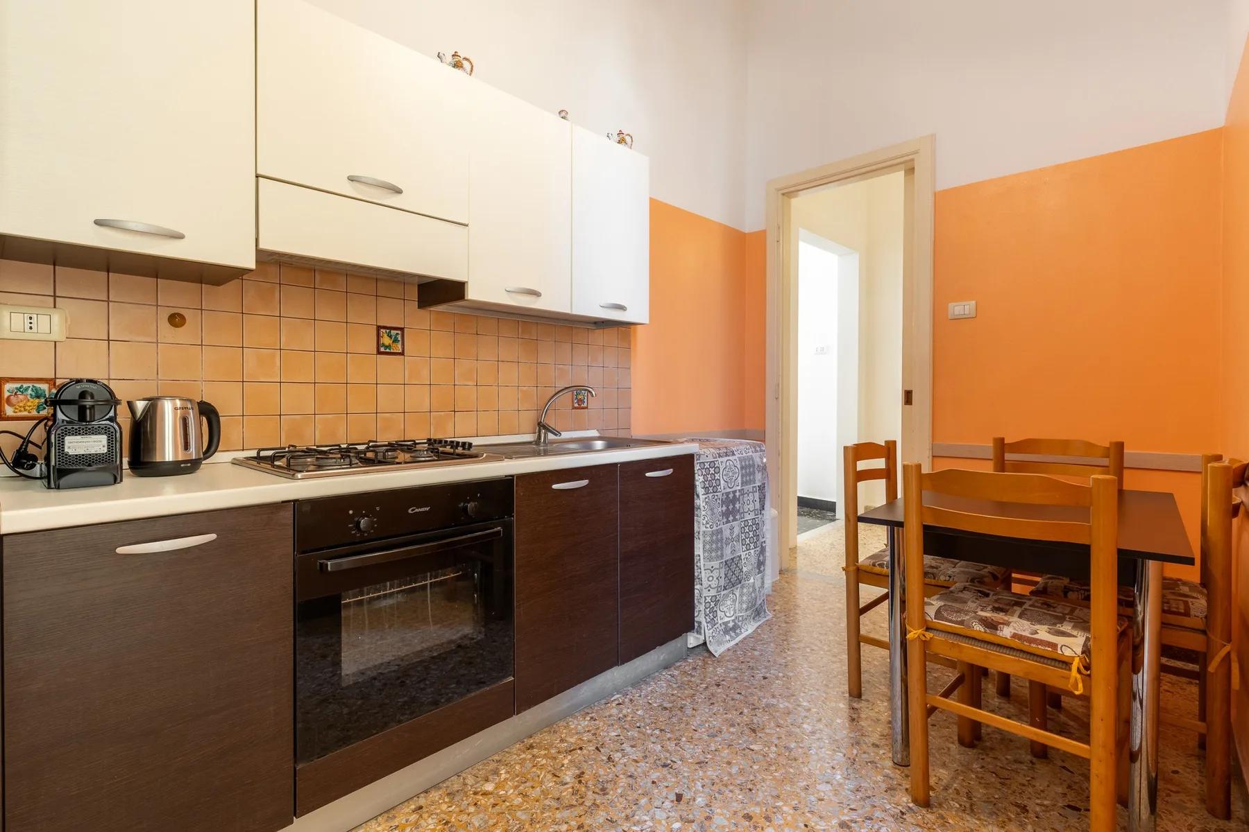 Una cocina con encimera, electrodomésticos de cocina y una mesa de comedor.