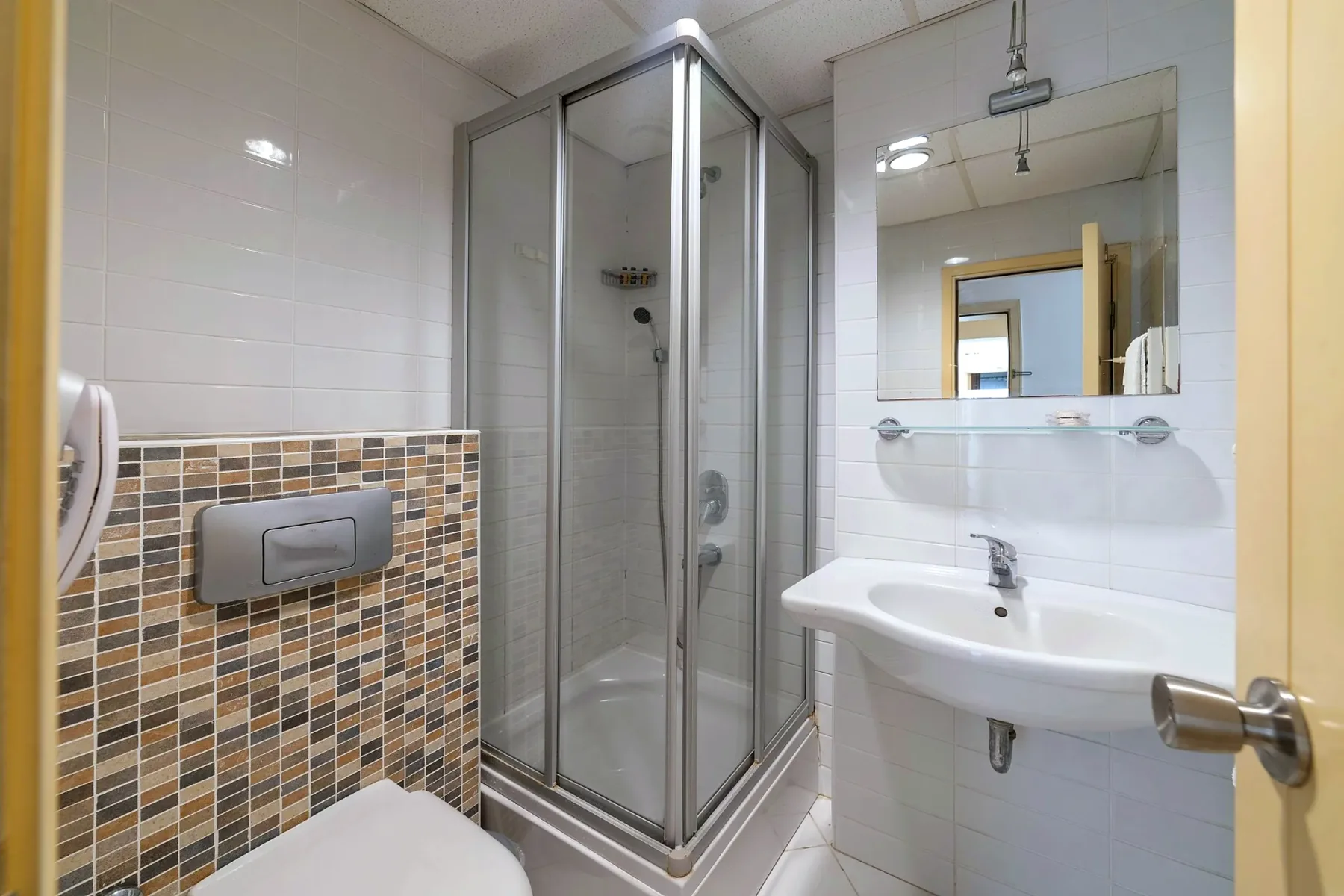 Baño de la habitación con ducha con mampara y lavabo
