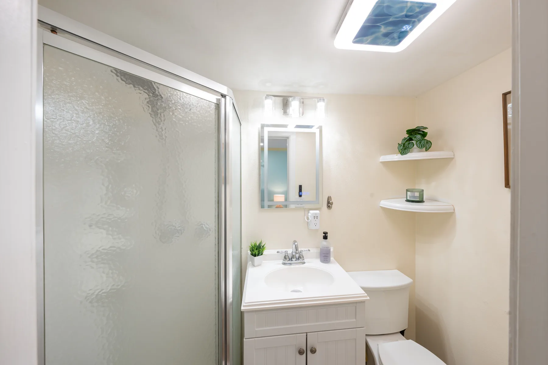 Un baño con lavabo, espejo y ducha.