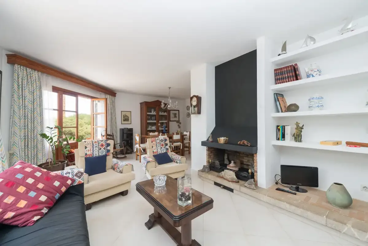 A bright living room with seating, a fireplace, and built-in shelves.