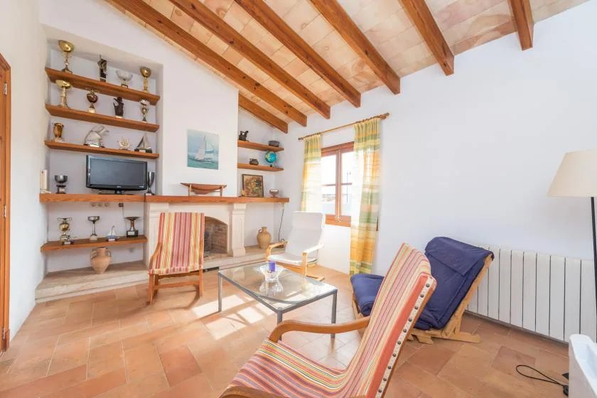 A bright living room with striped seating, display shelves, and a window.